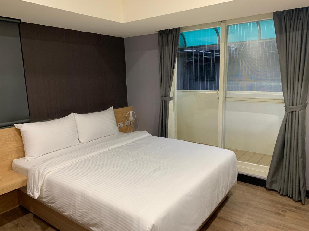 a bedroom with a large white bed and a window at CY Hotel in Taipei