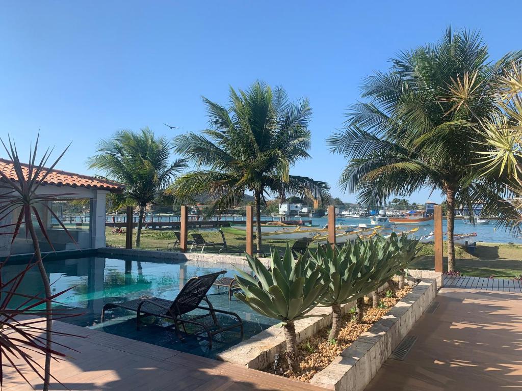 un complejo con una piscina con palmeras en Hotel Premium Recanto da Passagem, en Cabo Frío
