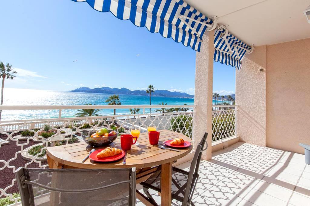 uma mesa numa varanda com vista para o oceano em Résidence Saint Rémy 2 em Cannes