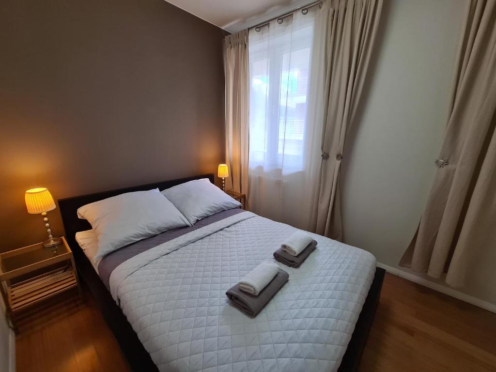 a bedroom with a bed with two towels on it at Lux Apartment Art in Polanica-Zdrój