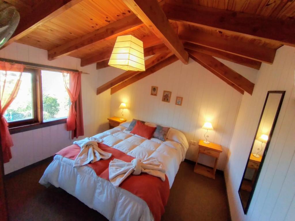 a bedroom with two beds in a room with wooden ceilings at Altos del Pucará Piscina Climatizada Juegos infantiles Huerta Orgánica in Huerta Grande