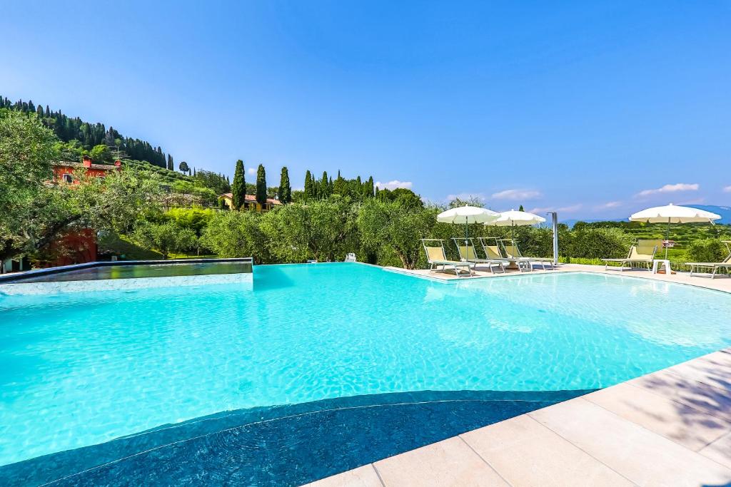 a large swimming pool with blue water at Casaliva Relais in Bardolino