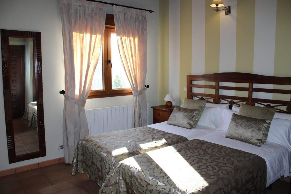 a bedroom with a large bed and a window at Finca Rincón de la Vega in Los Cortos