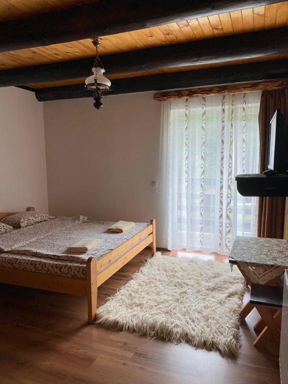 a bedroom with a bed and a large window at Pensiunea Puiu in Moieciu de Sus