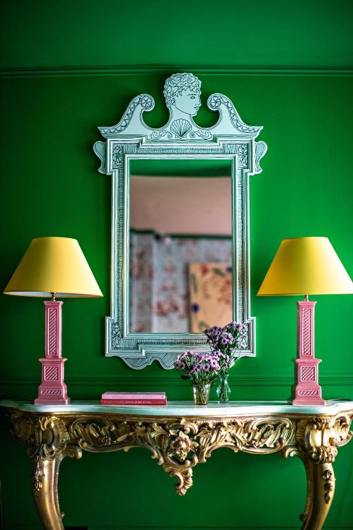 twee lampen op een tafel voor een groene muur bij Hôtel Les Deux Gares in Parijs