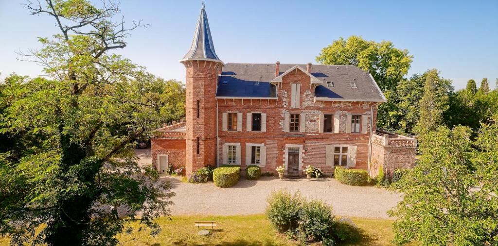 an old brick house with a tower on top of it at Domaine du Buc, Le Château in Marssac-sur-Tarn