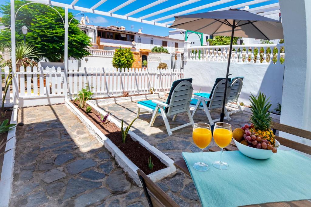 een tafel met twee glazen sinaasappelsap en een fruitschaal bij Bungalow Marta Agaete in Agaete