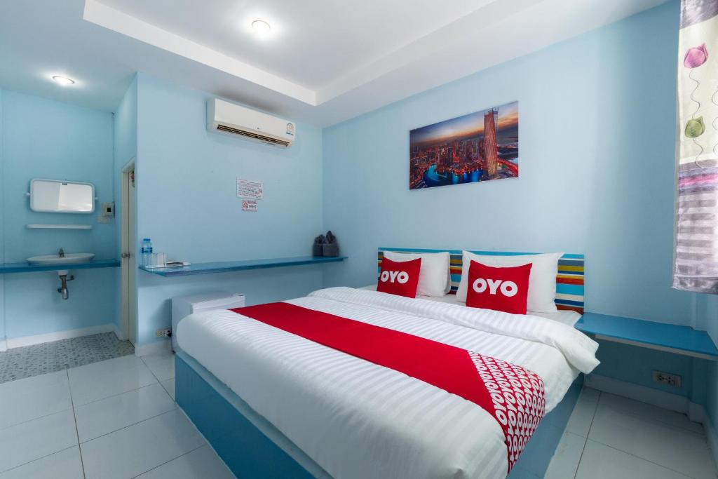 um quarto azul com uma cama grande e almofadas vermelhas em OYO 1133 Koh Chang Baantalay Resort em Ko Chang