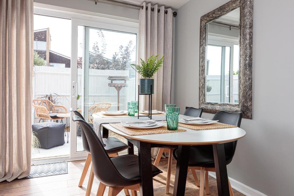 - une salle à manger avec une table, des chaises et un miroir dans l'établissement Laburnum By The Sea, à Lancing