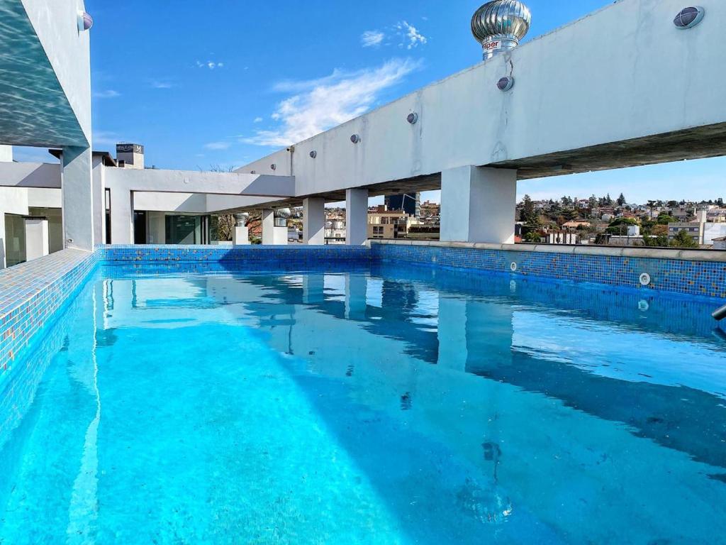 una gran piscina de agua azul en un edificio en Edificio Tempo en Villa Carlos Paz