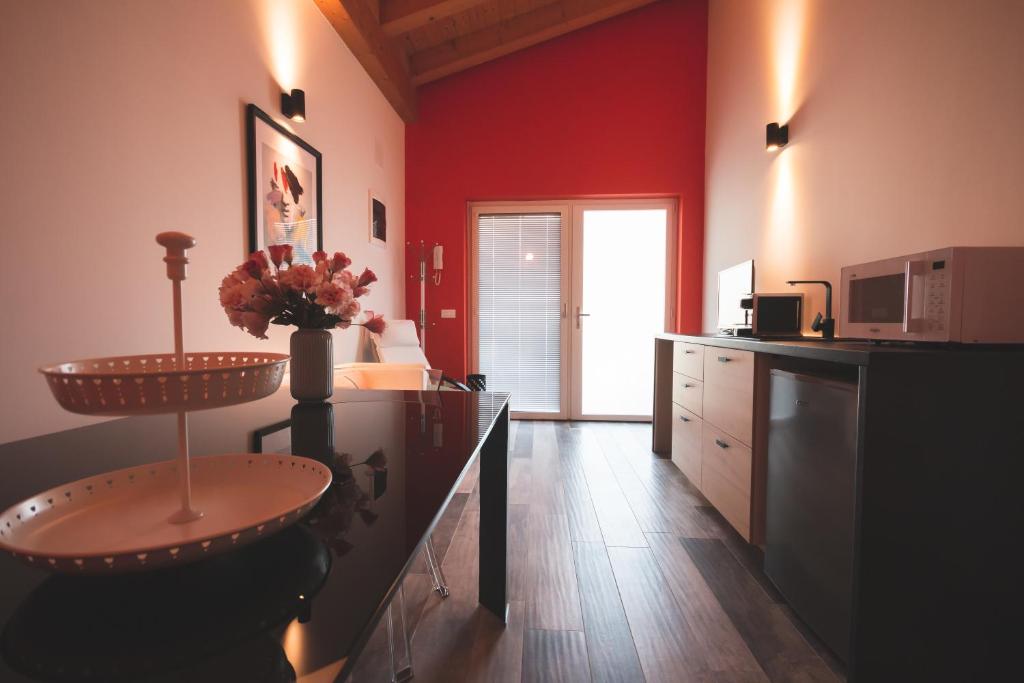 a kitchen with red walls and a counter with a sink at B&B OASI in Ronchi dei Legionari