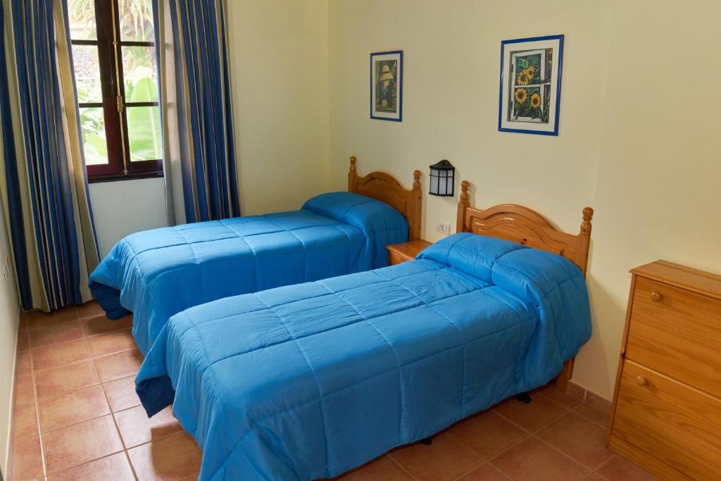 Habitación con 2 camas y sábanas azules. en Finca Piñero, en Hermigua