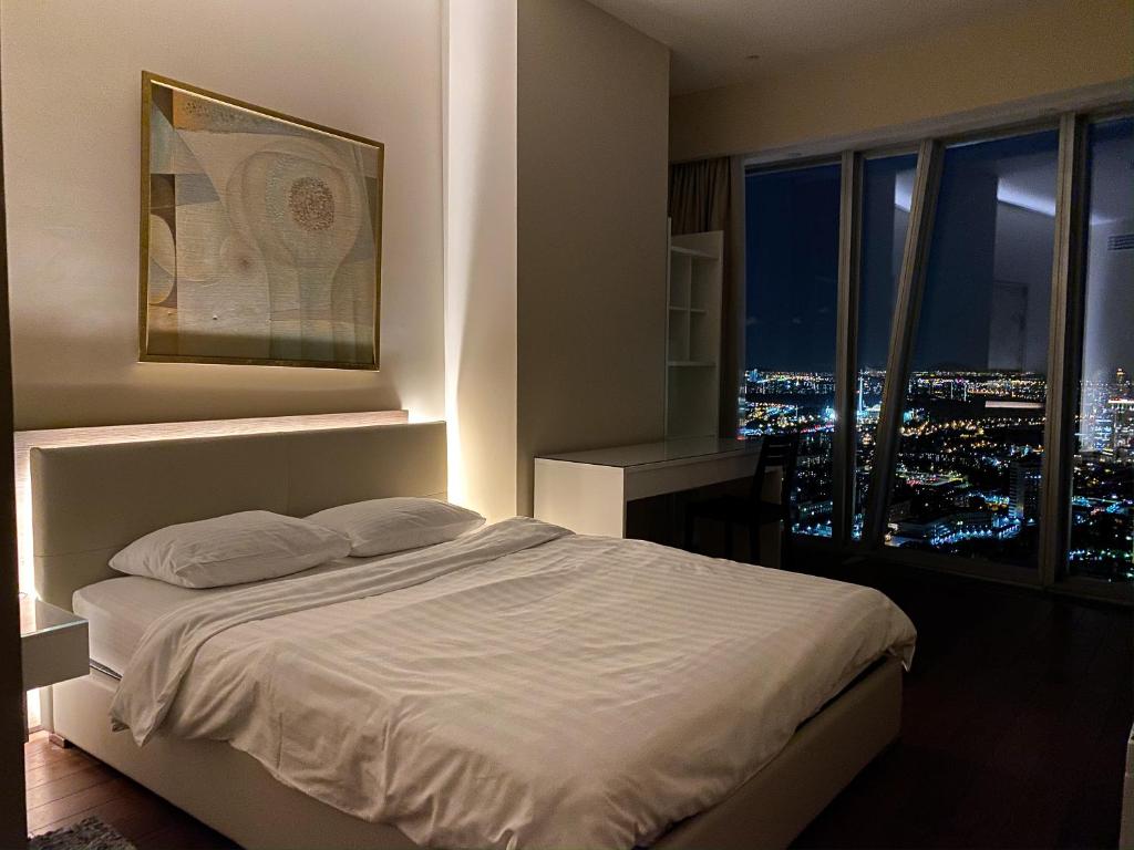 a bedroom with a bed with a view of a city at Moscow City Apartment Luxury Апартаменты Москва Сити 48-75 floors in Moscow