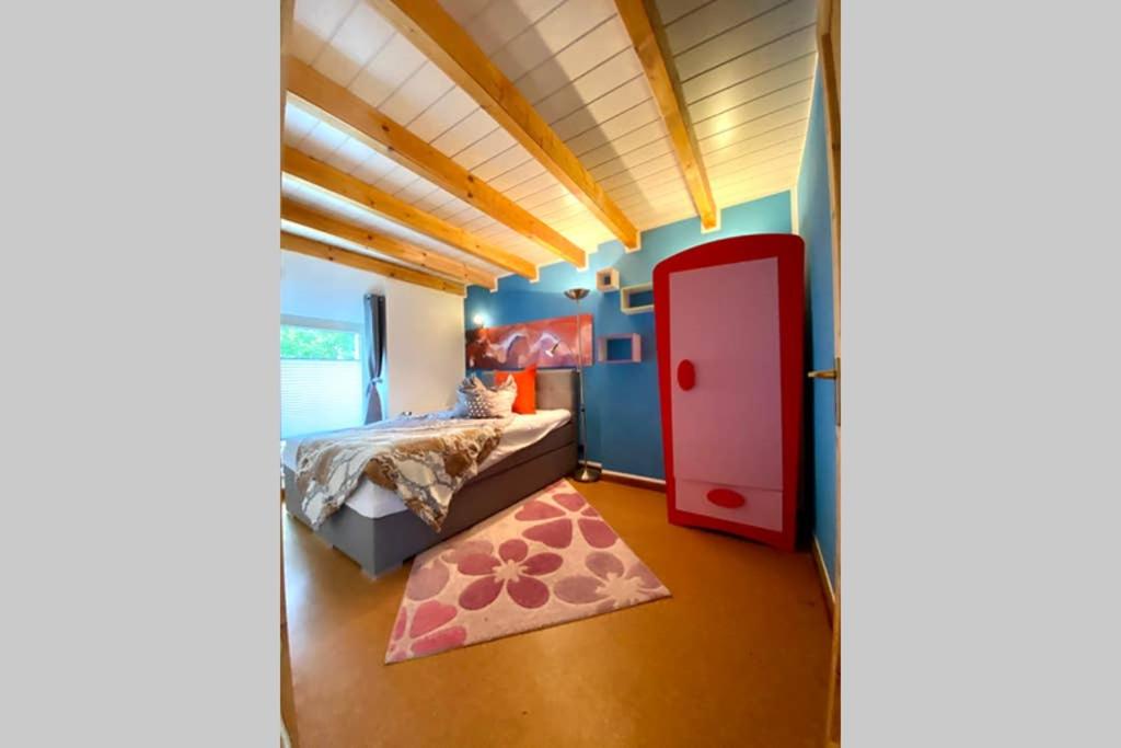 een slaapkamer met een bed en een rode deur bij Oldschool, Dorfschule mit Whirlpool in Kall