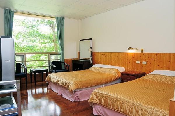 Habitación de hotel con 2 camas y ventana en 千禧山莊民宿 en Fengbin