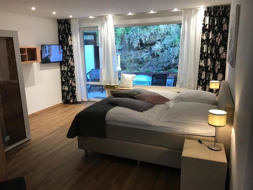 a bedroom with a large bed and a large window at Ferienapartment: An Der Kunstakademie Heimbach in Heimbach