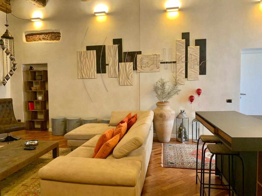 ein Wohnzimmer mit einem Sofa und einem Tisch in der Unterkunft Kindness art apartment in historic center in Arona