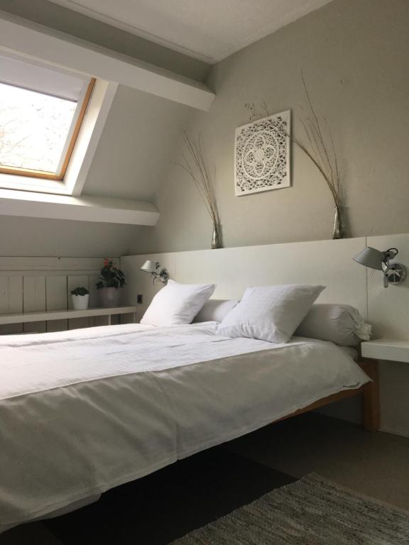 a bedroom with a large white bed with a window at Hotelroom Villa 1913 in Bergen