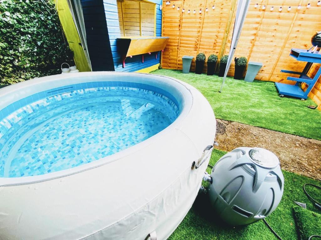 a large hot tub in a yard with a soccer ball at Spacious Canterbury City Centre Gem House with Parking in Canterbury