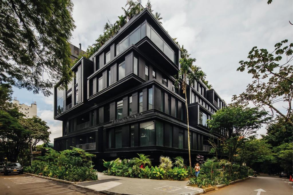a black building with trees on top of it at The Click Clack Hotel Medellín in Medellín
