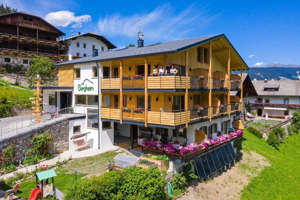 a building with a balcony with people on it at Residence Bergheim in Braies
