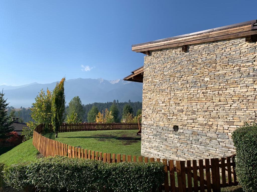 um edifício de tijolos com uma cerca num quintal em Katarino Mountain House em Razlog