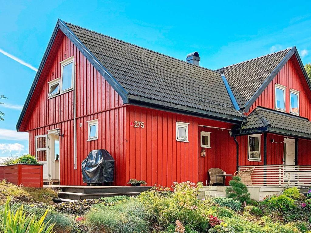 ein rotes Haus mit schwarzem Dach in der Unterkunft Apartment EYDEHAVN in Eydehamn