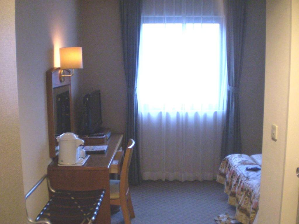 Postel nebo postele na pokoji v ubytování Shingu UI Hotel