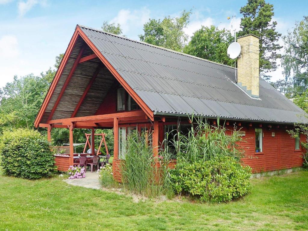 a red cabin with a black roof at Holiday home Glesborg XL in Glesborg