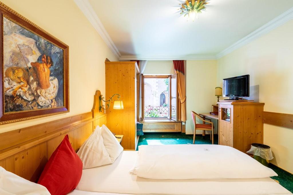 a hotel room with a bed and a desk at Hotel Zum Schwarzen Bären in Emmersdorf an der Donau