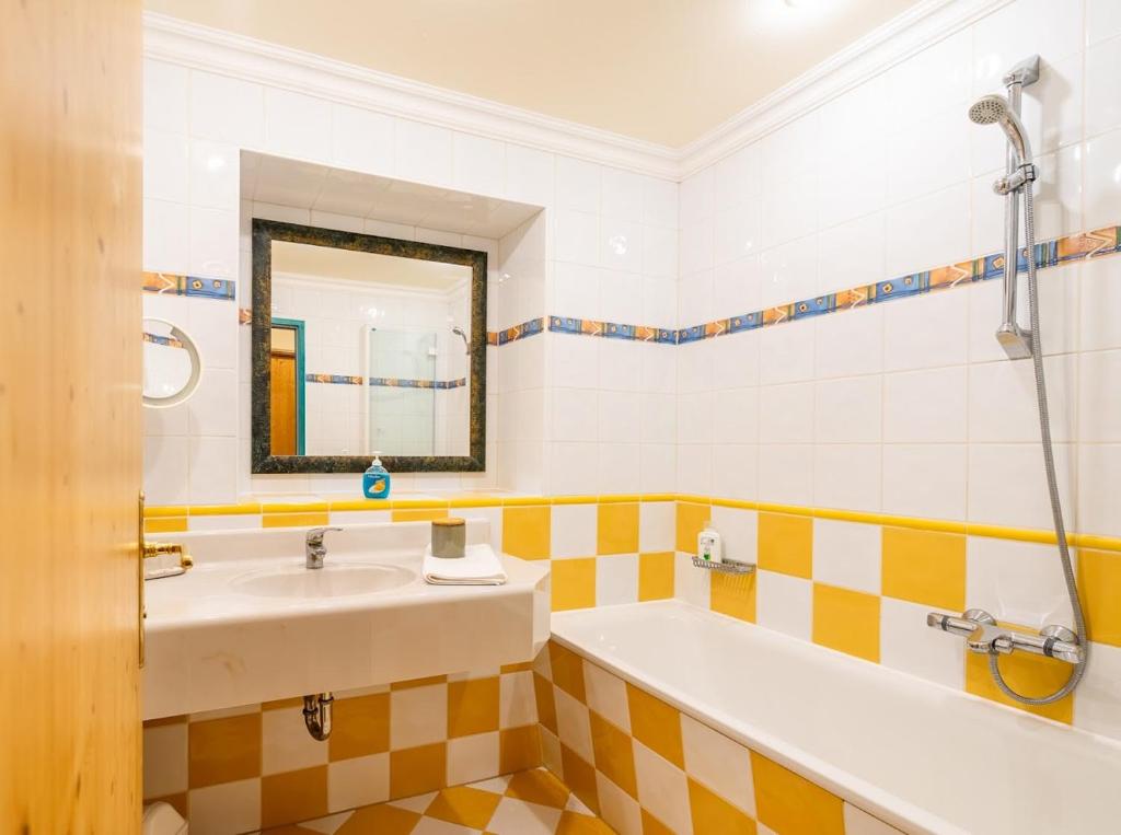 a bathroom with a sink and a bath tub at Hotel Zum Schwarzen Bären in Emmersdorf an der Donau