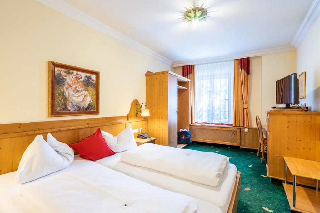 a hotel room with two beds and a television at Hotel Zum Schwarzen Bären in Emmersdorf an der Donau