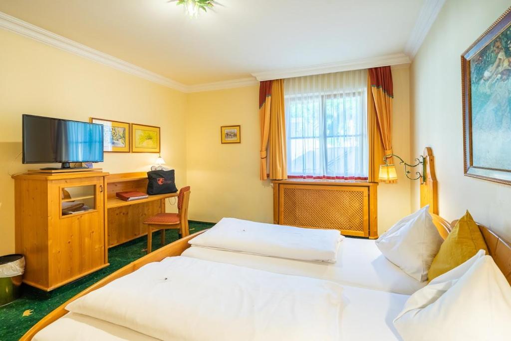 a hotel room with two beds and a television at Hotel Zum Schwarzen Bären in Emmersdorf an der Donau