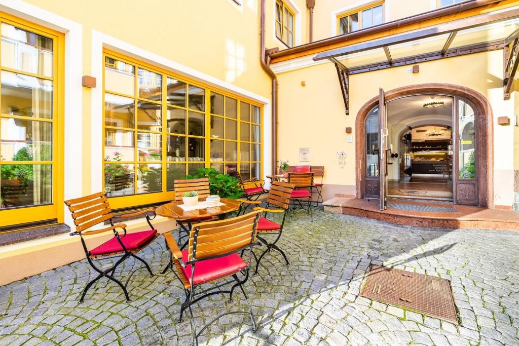 a patio with chairs and tables and a building at Hotel Zum Schwarzen Bären in Emmersdorf an der Donau