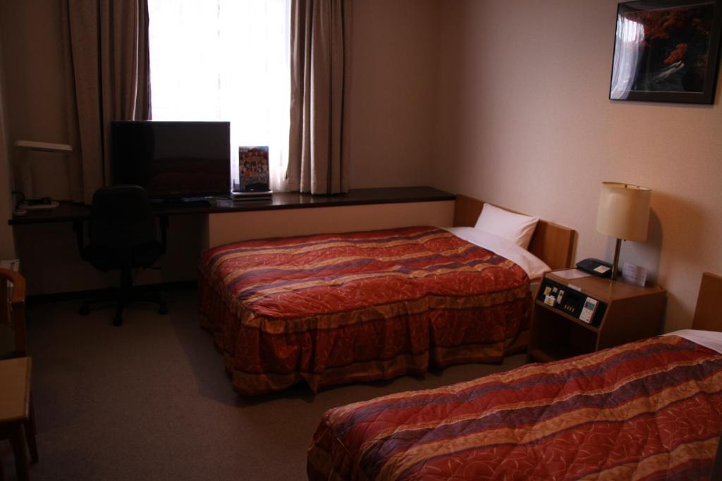 Postel nebo postele na pokoji v ubytování Shingu Central Hotel