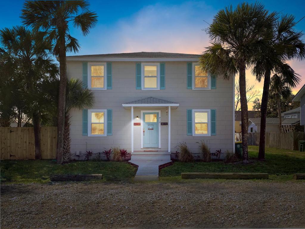 a white house with palm trees in front of it at Upper Unit - 4 blocks to the beach, restaurant, and bar district - great deck! in Jacksonville Beach