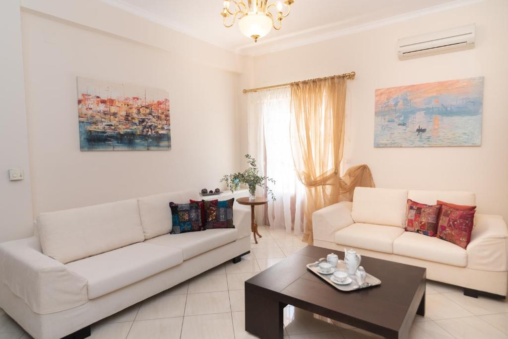 a living room with two white couches and a coffee table at Katerina's House in Vathi