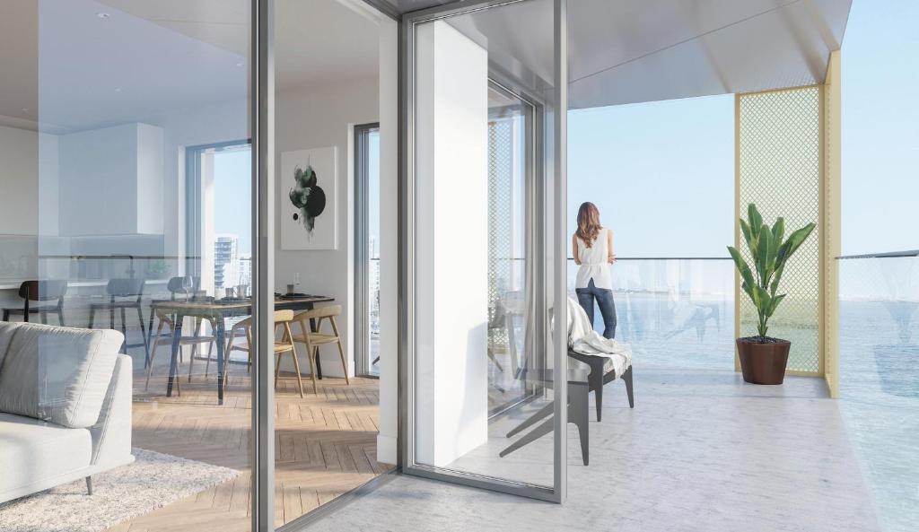 a woman walking through a living room with glass doors at Medway Chatham Waters in Gillingham