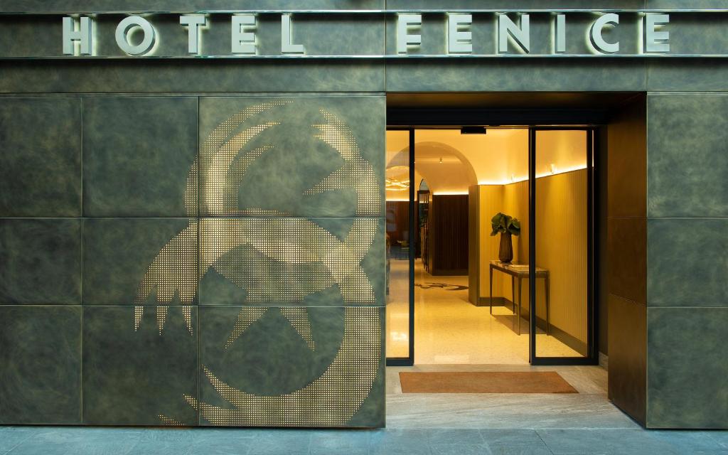 une façade d'entrée d'hôtel avec un panneau sur celle-ci dans l'établissement Hotel Fenice, à Milan