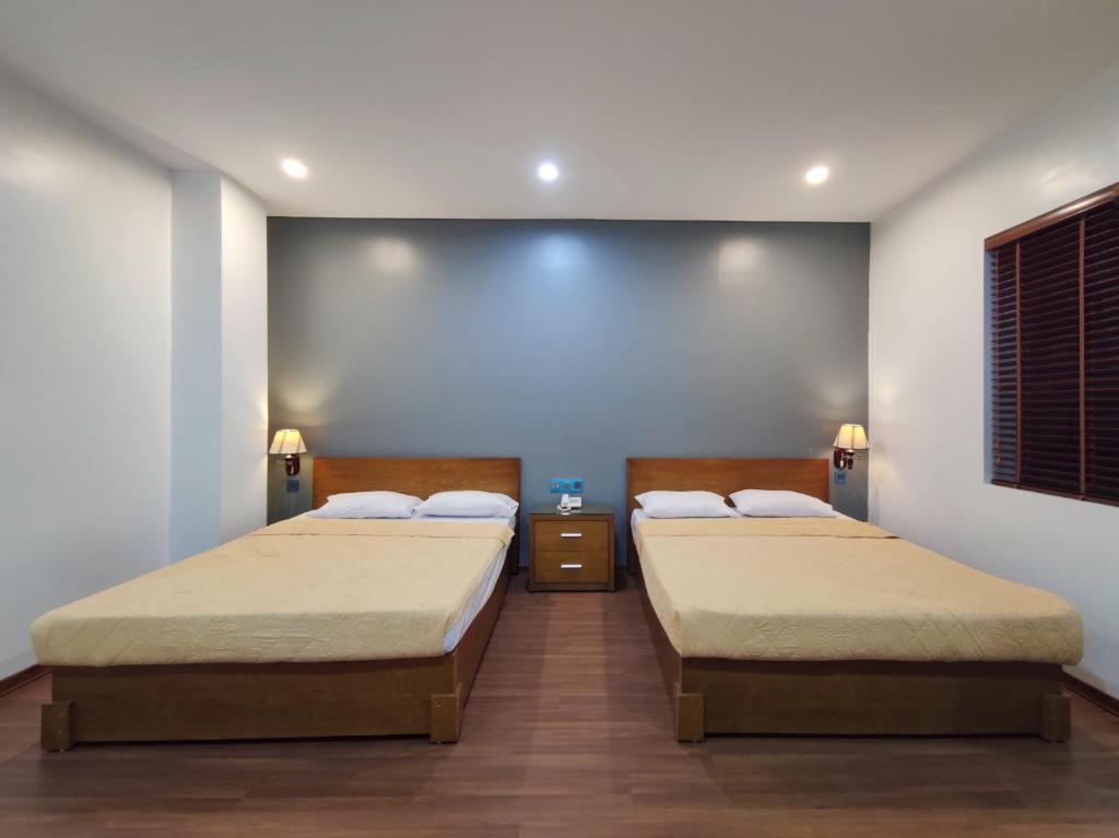 two beds in a room with two at Gieng Ngoc Hotel in Cat Ba