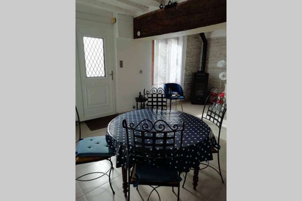uma sala de jantar com mesa e cadeiras em petite maison de ville toute équipée em Château-Renard