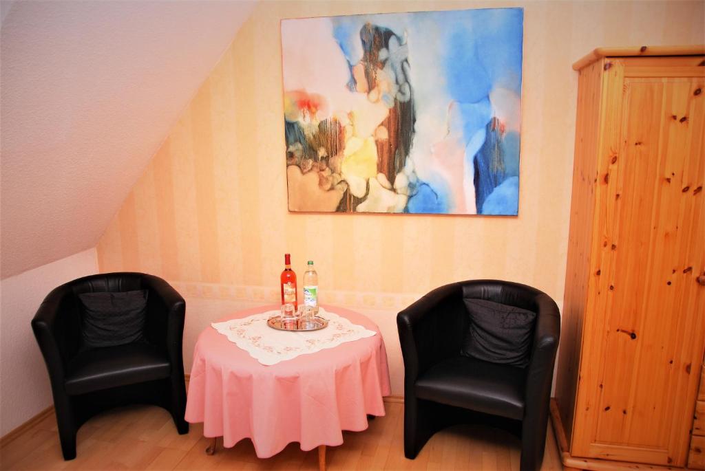 einen Tisch mit 2 Stühlen und einen Tisch mit 2 Flaschen Wein in der Unterkunft Apartment Renate in Oberasbach