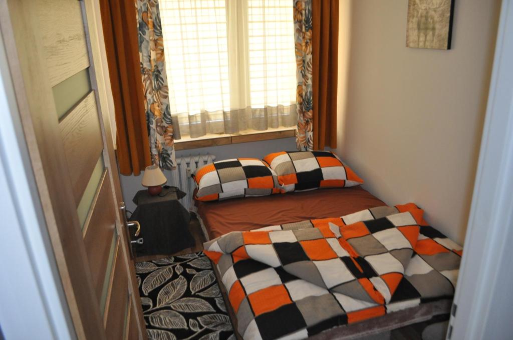 a small bedroom with two beds and a window at Apartament Sierakowskiego in Sanok