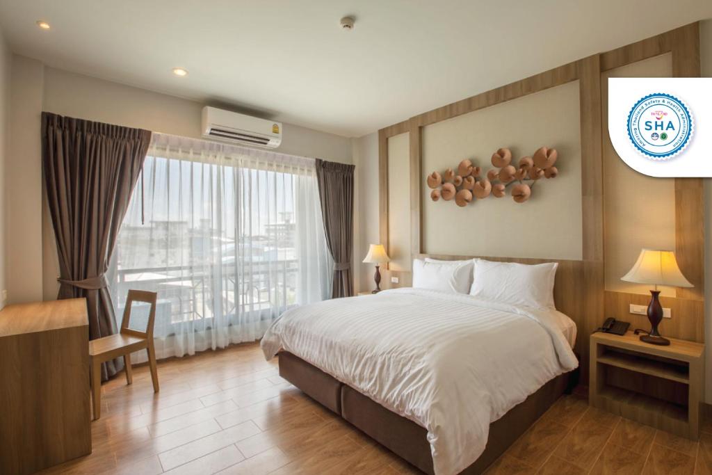 um quarto de hotel com uma cama e uma janela em Civilize Hotel em Udon Thani