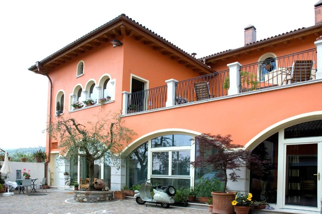 an orange building with a scooter parked in front of it at La Villetta in Raffa