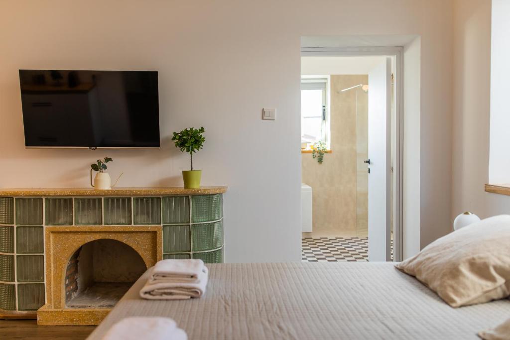 a bedroom with a fireplace and a tv on the wall at Rooms - Unique staying in Paphos Centre in Paphos City
