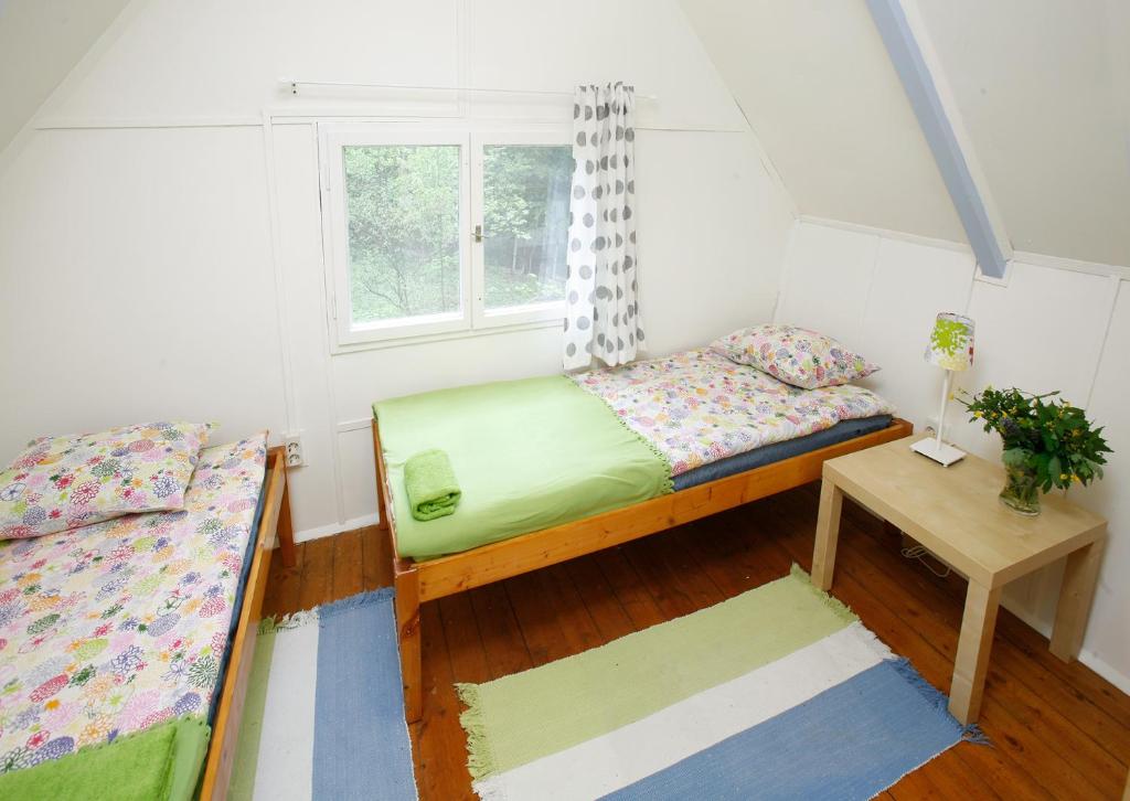 Habitación pequeña con 2 camas y ventana en Harangvirág 36 Faház en Kismaros