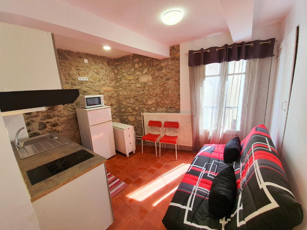 a living room with a bed and a kitchen with a sink at APPARTEMENT AGATHOIS-2 in Agde
