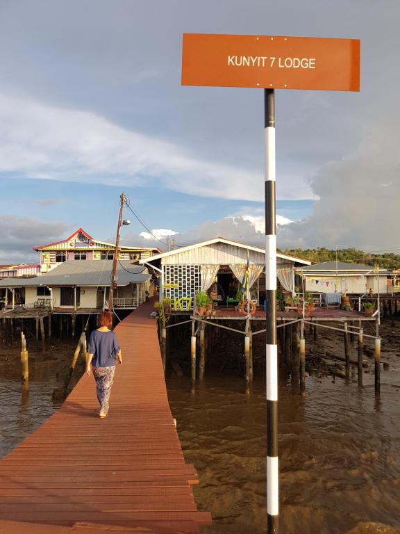 a man walking on a dock in the water at Kunyit 7 Lodge in Bandar Seri Begawan