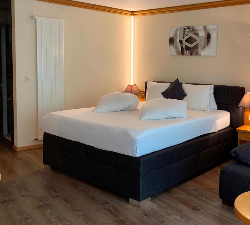 Postel nebo postele na pokoji v ubytování Hotel Quellenhof Leukerbad